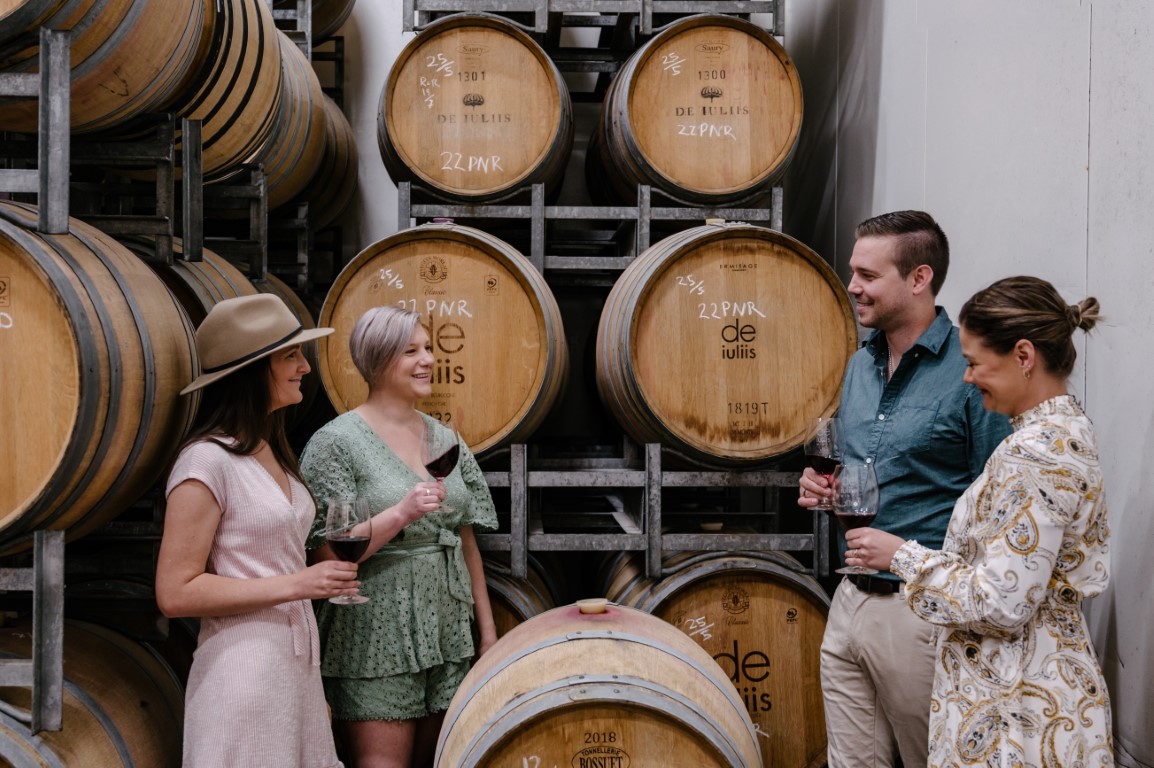 People  drinking De Iuliis wine at the barrel room 